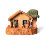 Casinha azul em miniatura com brincadeiras de criança - Claudio Henrique