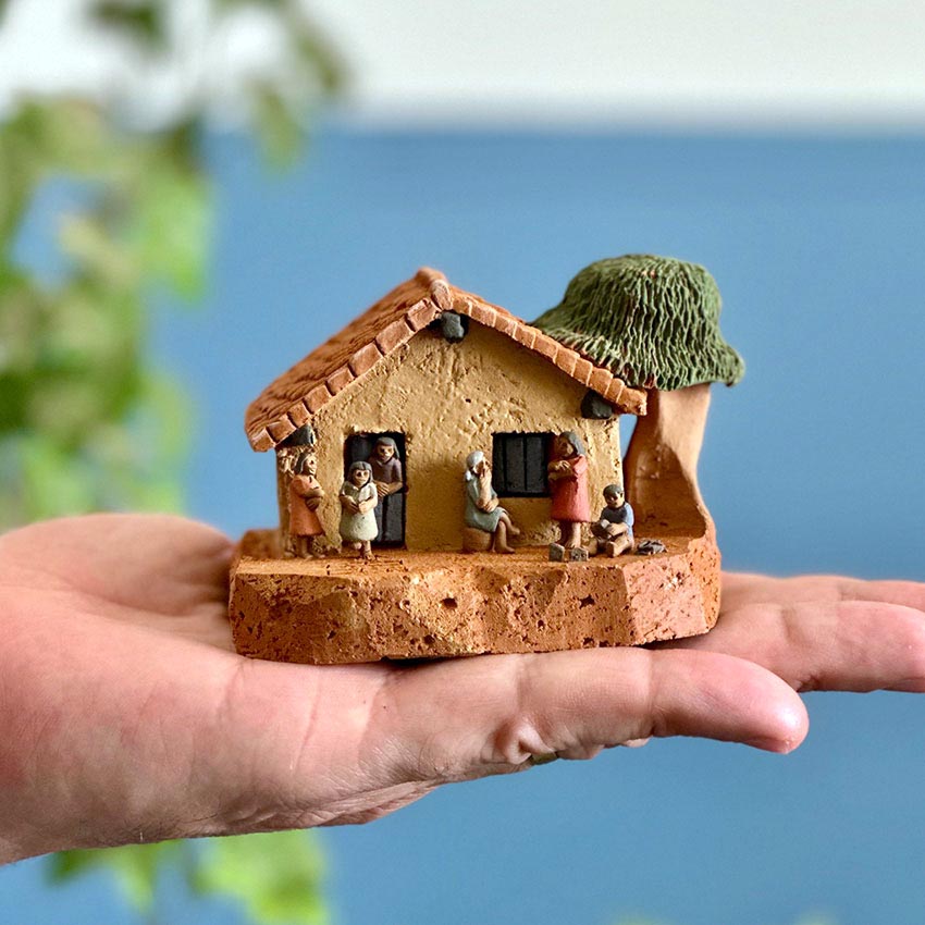 Casinha azul em miniatura com brincadeiras de criança - Claudio Henrique
